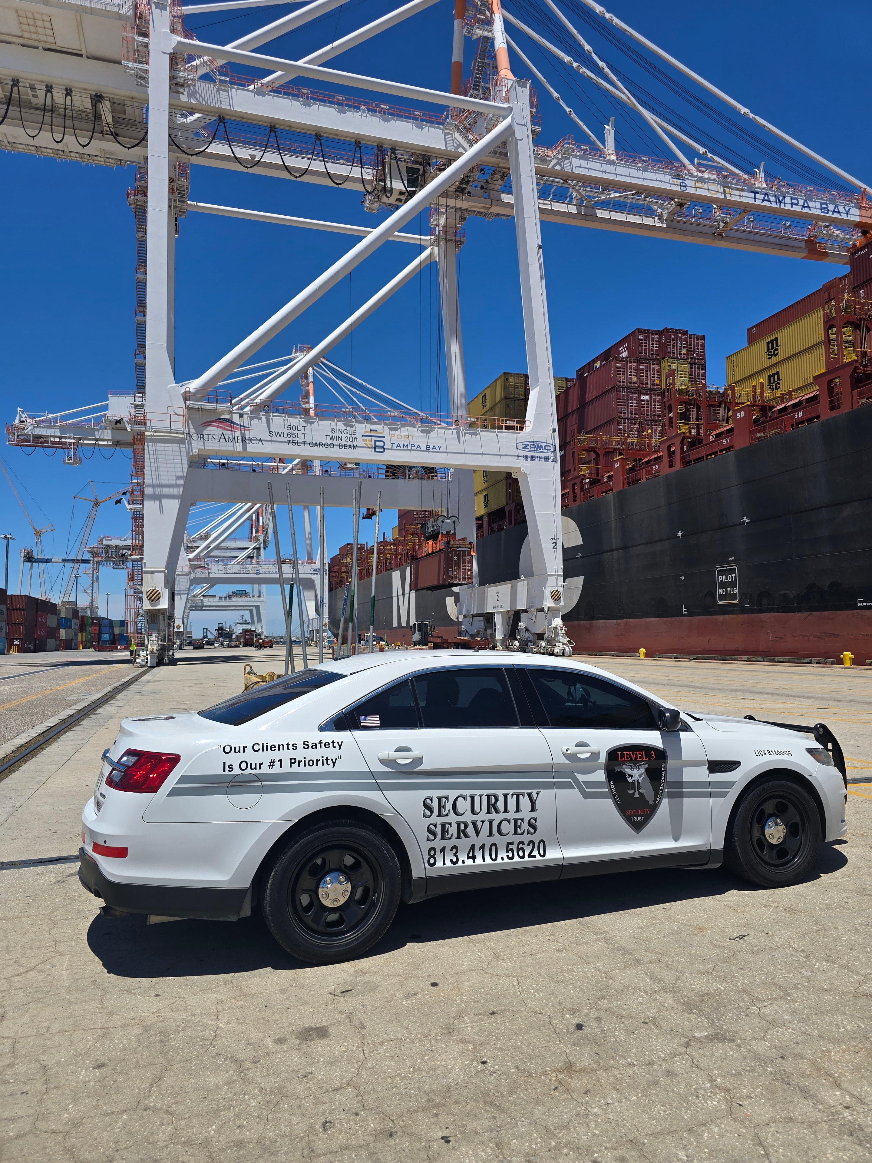 Level 3 Security branded vehicle at Tampa Bay port with shipping containers and cranes