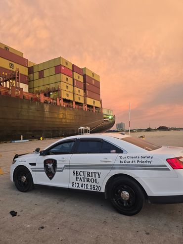 Security patrol vehicles at port with shipping containers